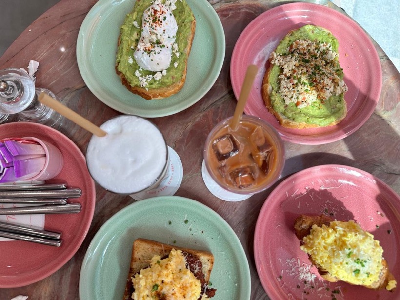 Brunch plates with avocado toast and iced coffee on pink plates