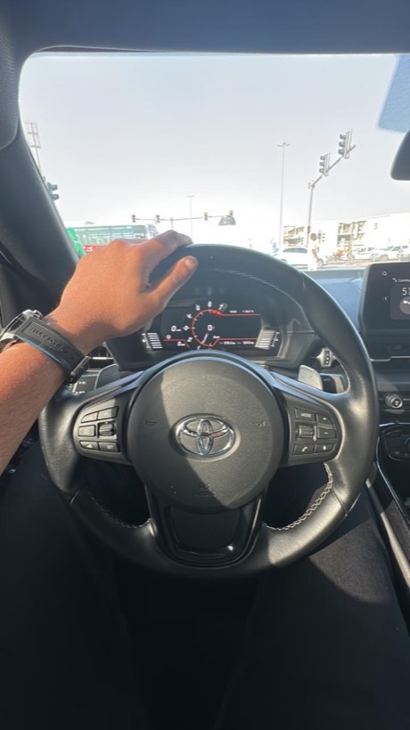 Hands on a Toyota steering wheel, driving