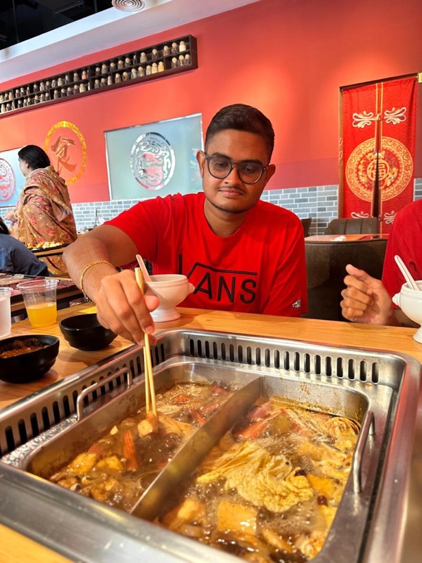 Enura cooking at a hotpot table with chopsticks