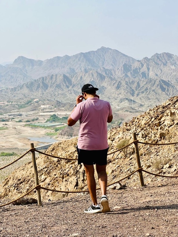 Enura on a mountain trail looking out over rocky peaks